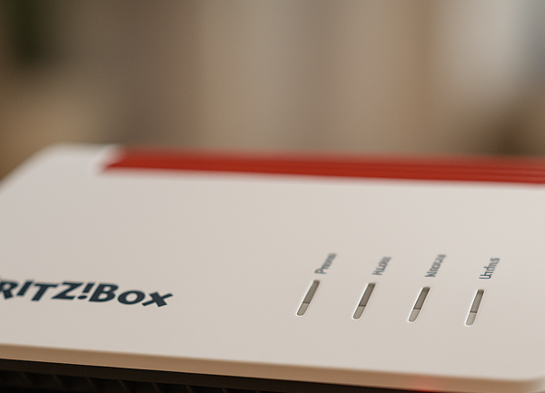 WLAN-Router auf Tisch, rote Info-LED leuchtet – Hinweis auf Störung oder Fehler.